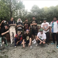 a group of people posing in front of a fence